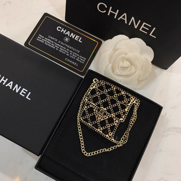 BAG SHAPED BROOCH IN GOLD METAL WITH BLACK CRYSTAL