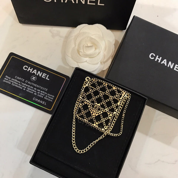BAG SHAPED BROOCH IN GOLD METAL WITH BLACK CRYSTAL